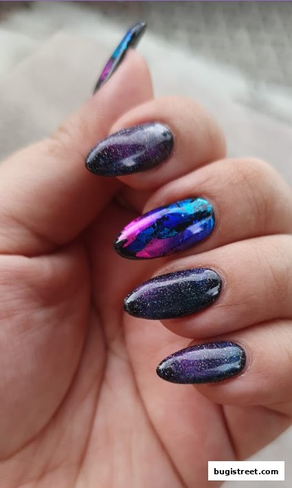 Close-up of a hand with beautifully designed galaxy-themed nails.