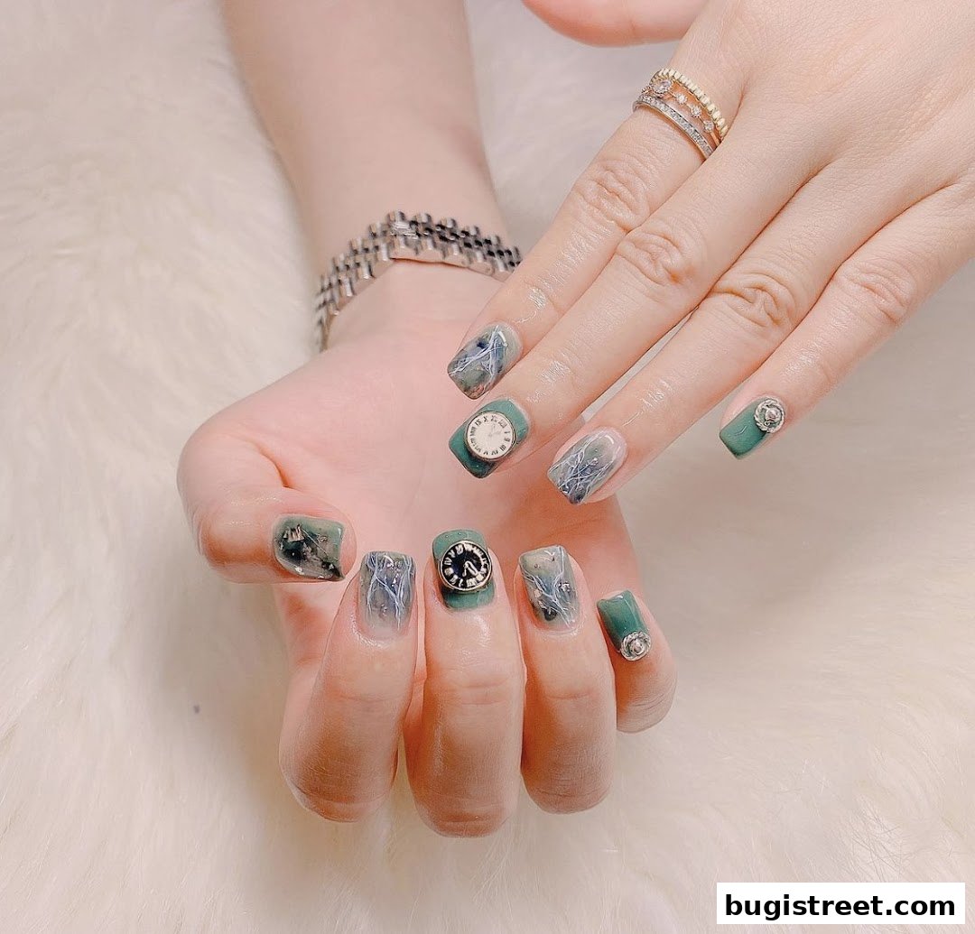 Close-up of hands with intricate nail art featuring clock designs and metallic accents.