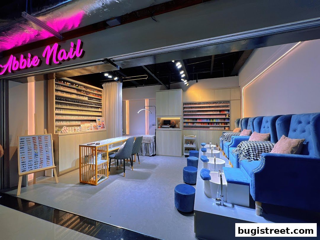 Interior of a modern nail salon with blue velvet pedicure chairs and a wide selection of nail polishes.