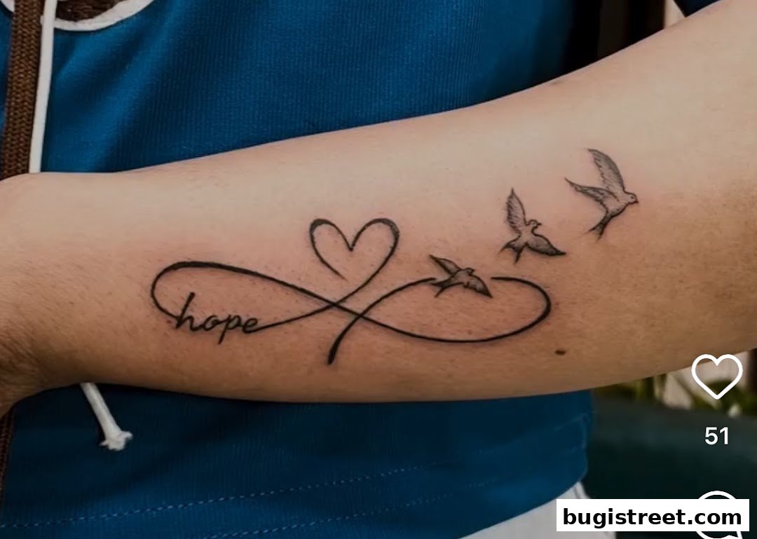 A tattoo of an infinity symbol with a heart and birds, featuring the word 'hope'.