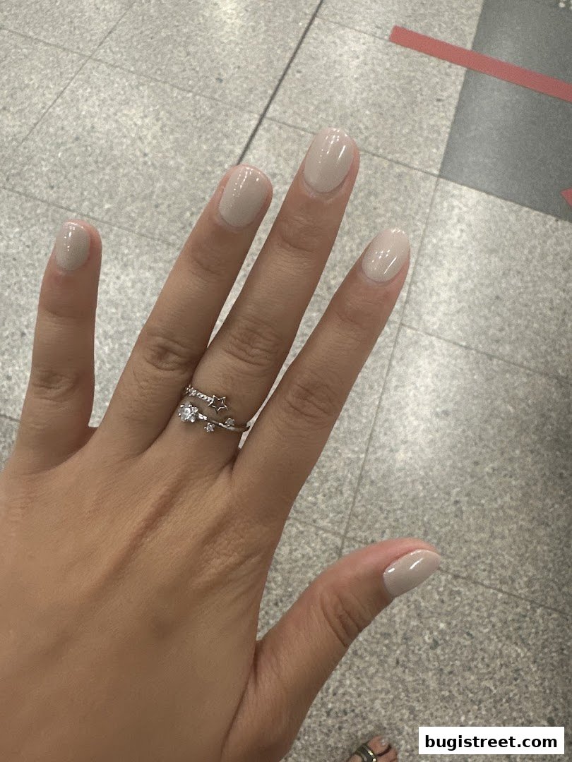 A close-up of a hand with neatly manicured nails painted in a subtle, neutral shade.
