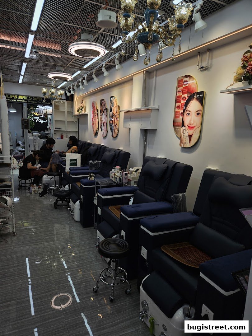 Interior of a nail salon with multiple pedicure chairs and staff attending to clients.