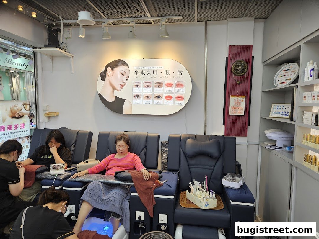 People receiving foot and nail treatments in a beauty salon with promotional displays.
