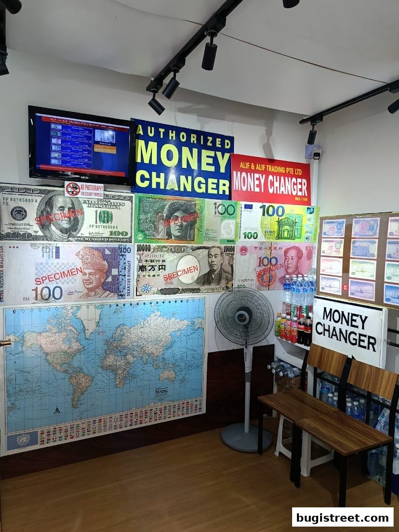 Interior of a money changer shop with currency displays, a world map, and seating.