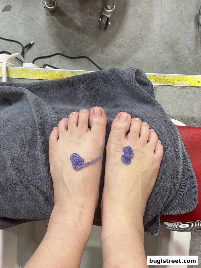 A close-up of feet with purple gel designs applied to the top of each foot.