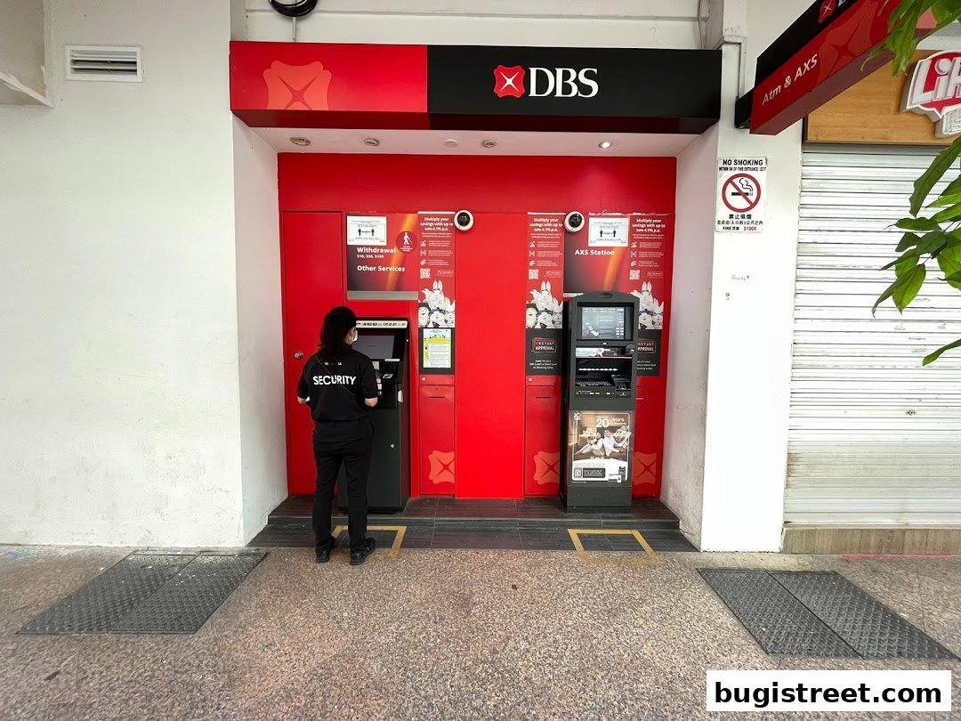 A security guard stands at an AXS station with DBS branding, offering various services.