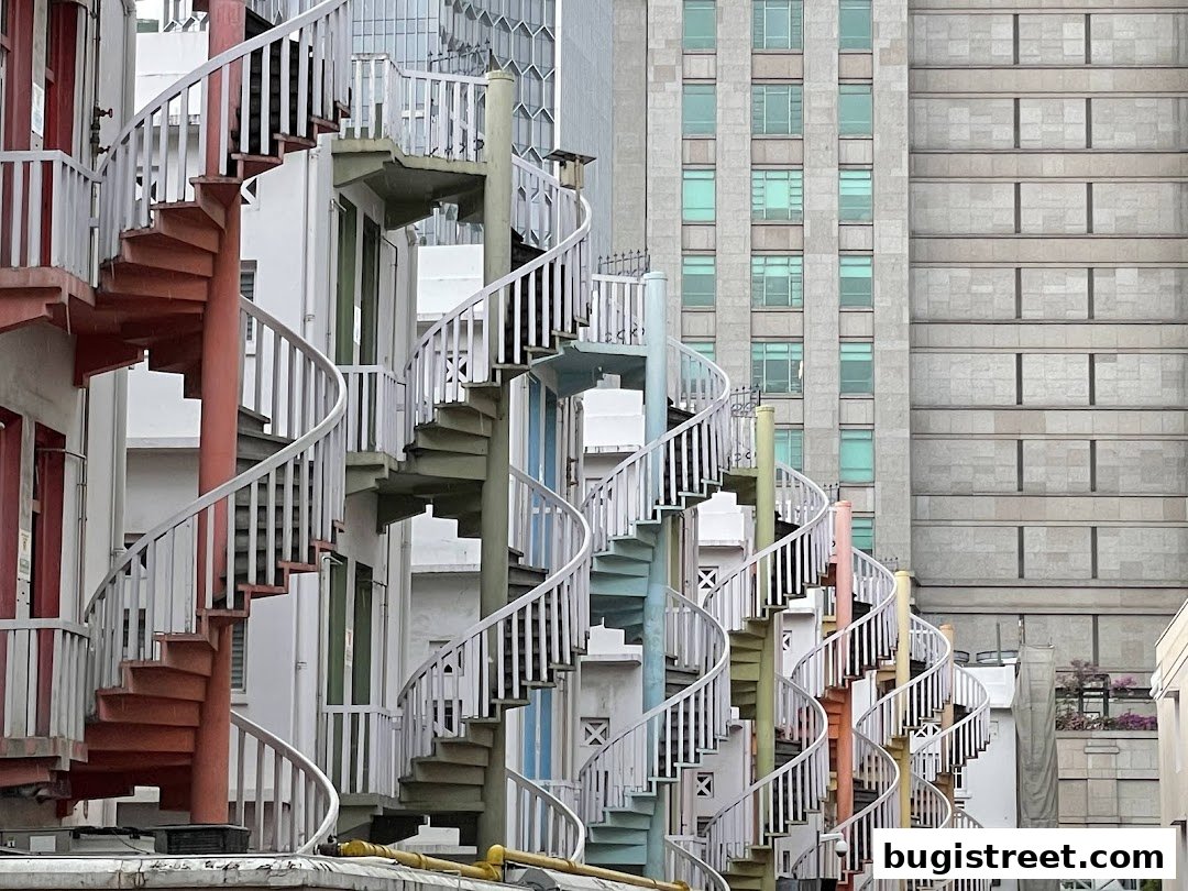 Colorful spiral staircases ascend against a backdrop of modern buildings.