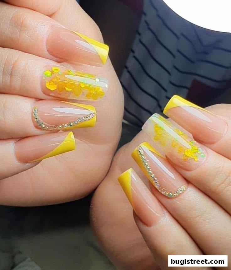 Close-up of hands with beautifully designed yellow French tip and floral accent nails.