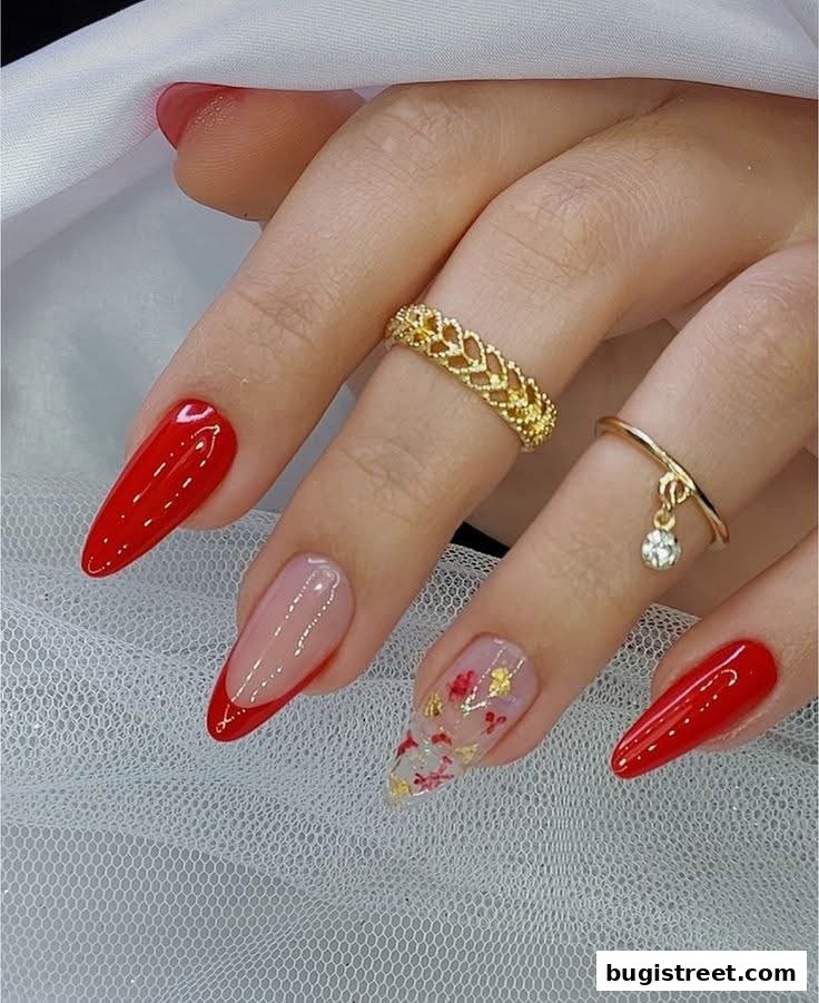 A close-up of a hand showcasing beautifully manicured nails with red polish and intricate designs.