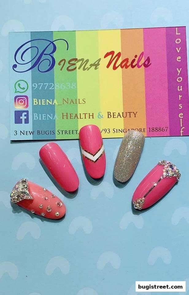 A display of five beautifully designed artificial nails, showcasing vibrant colors and intricate embellishments.