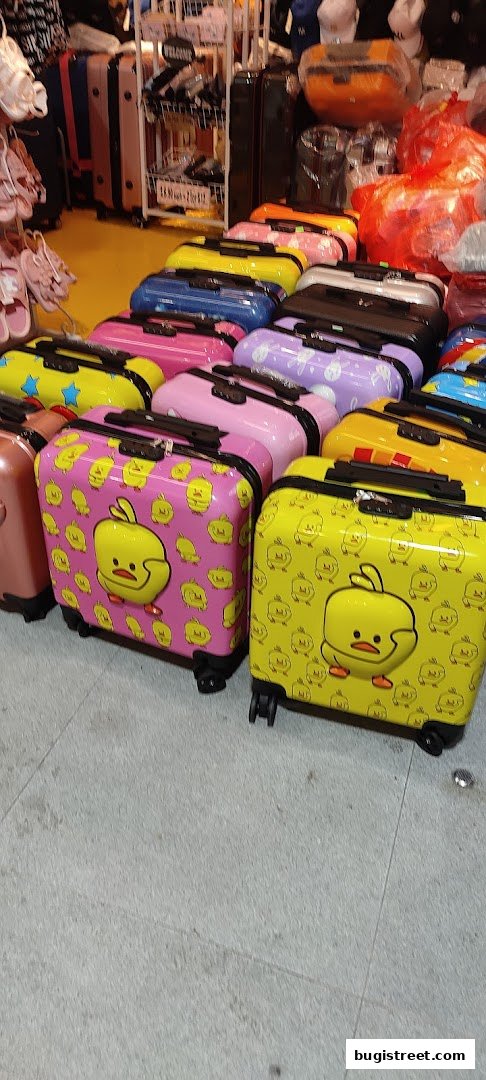 A colorful display of character-themed luggage, including duck and bunny designs.