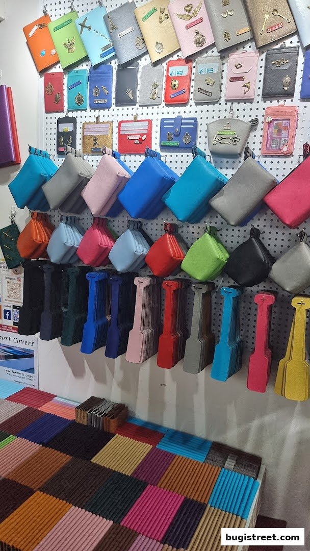 A display of colorful passport covers, cardholders, and pouches with various charms and accessories.