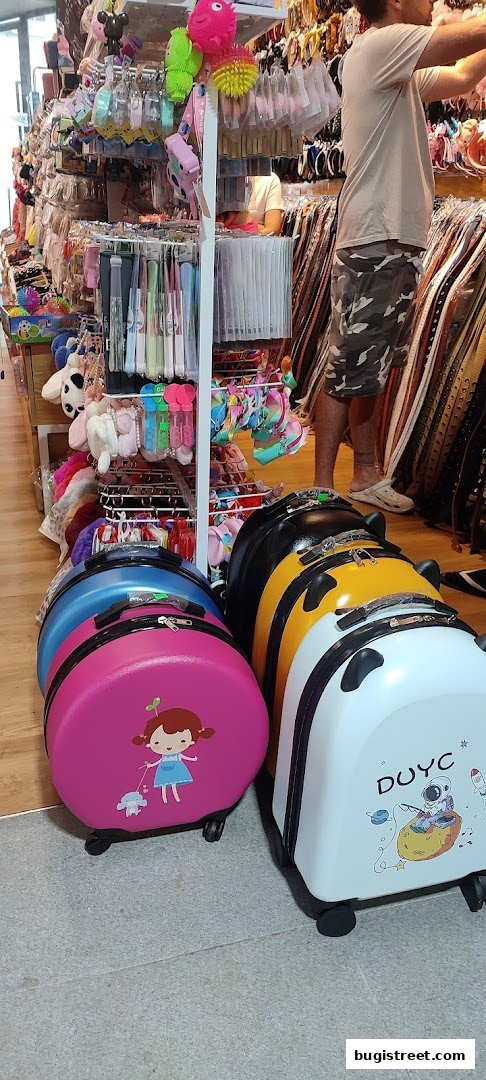 A shop interior displaying colorful luggage, accessories, and a person browsing.