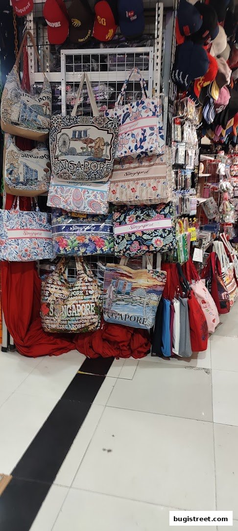 A display of various tote bags and caps with Singapore-themed designs.