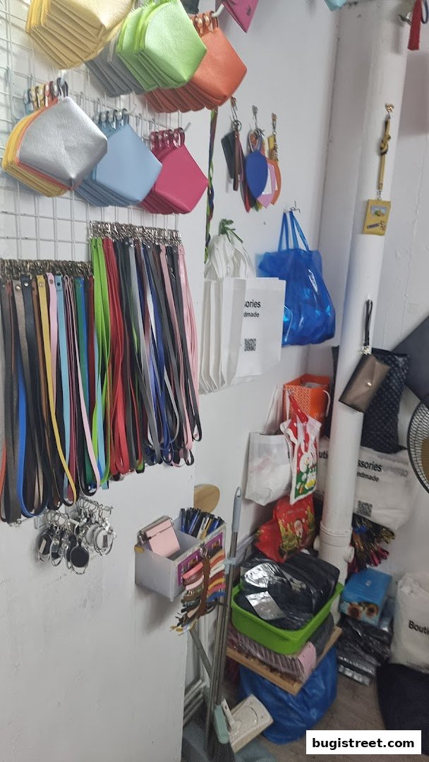 A shop interior displaying a variety of colorful accessories like purses, lanyards, and keychains.