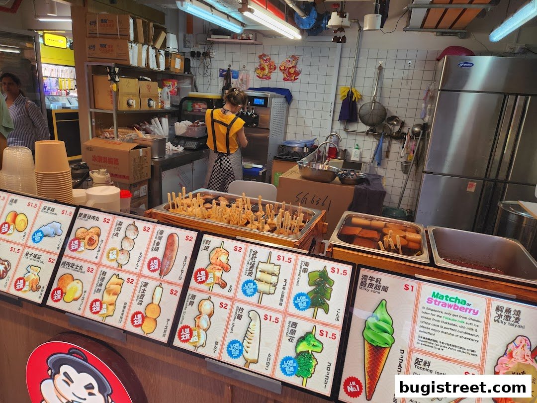 A display of various food items and ice cream with prices at a Japanese street food stall.