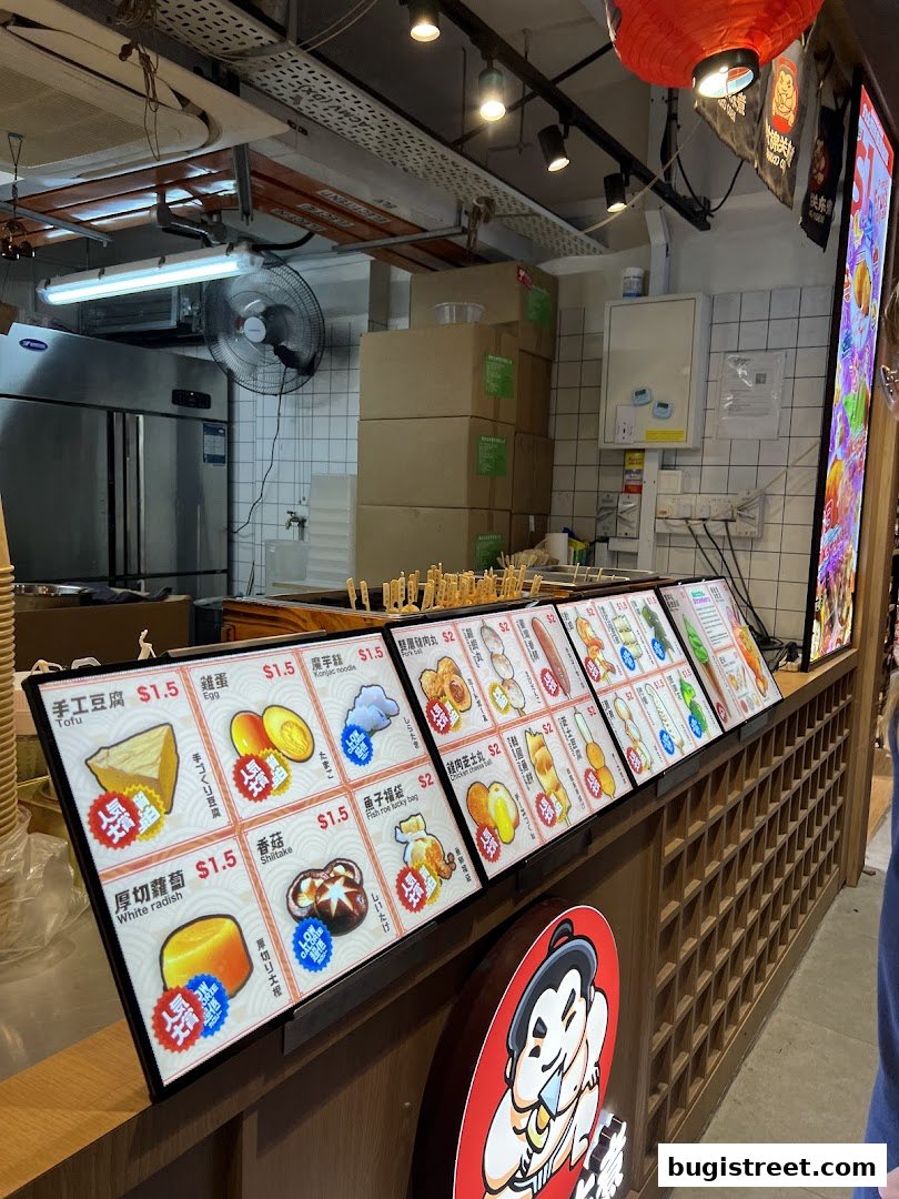 A display of various food items with prices at a Japanese Oden shop.