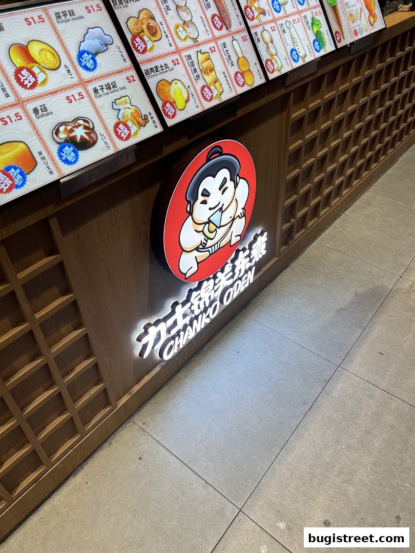 A brightly lit menu display for Chanko Oden, showcasing various food items with prices.