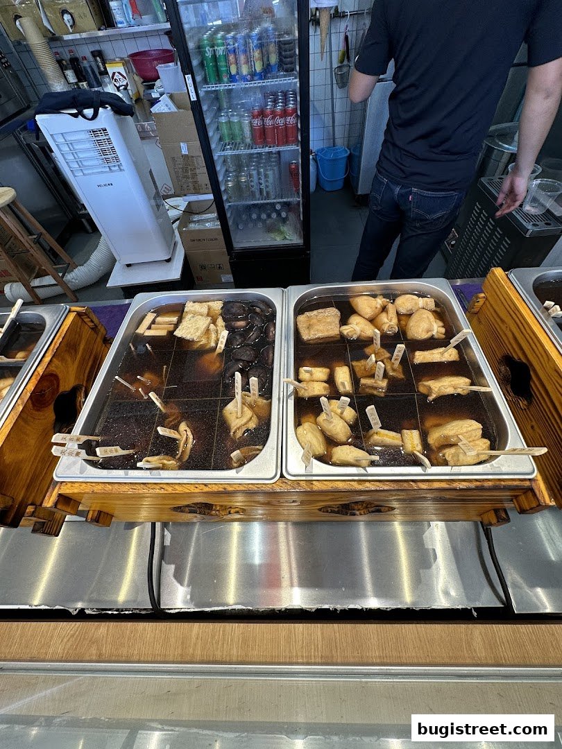 Two large metal trays filled with various oden ingredients simmering in broth.