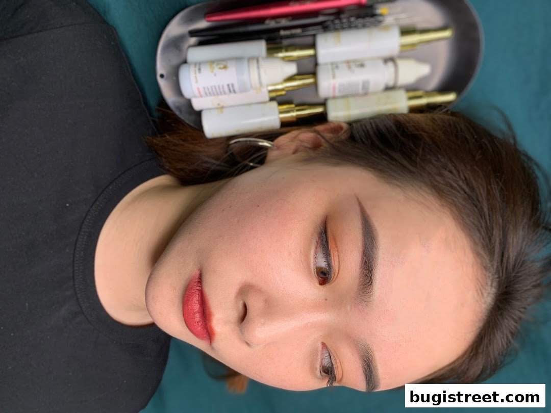 A close-up of a woman's face with expertly applied makeup and a tray of beauty products.