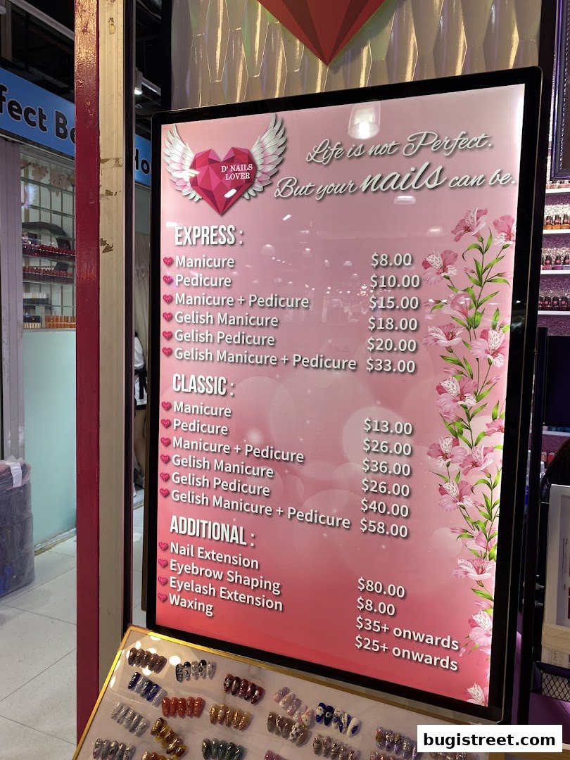 A pink menu board for D' Nails Lover, showcasing nail services and prices.