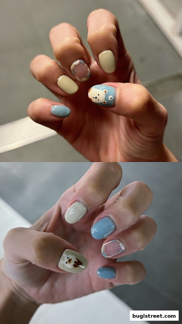 Close-up of hands showcasing creative nail art with cute animal designs and pastel colors.