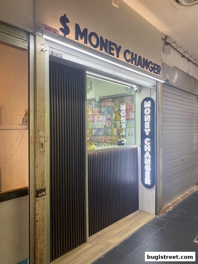 The exterior of a modern money changer shop with prominent signage and a display of currency.