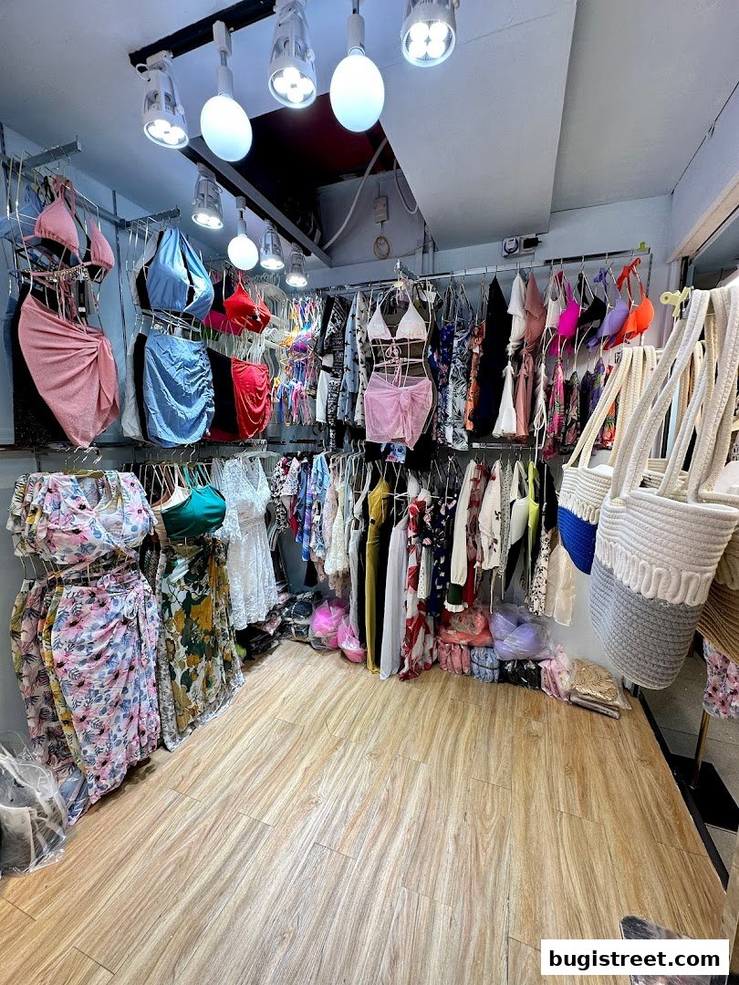 A retail shop interior displaying a variety of women's clothing, including swimwear and dresses.