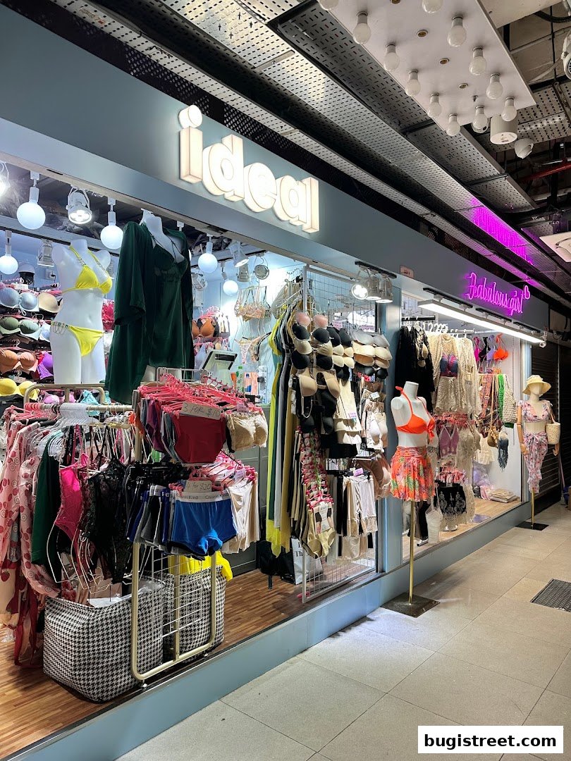 A brightly lit shop front displaying a variety of lingerie and swimwear on mannequins and racks.