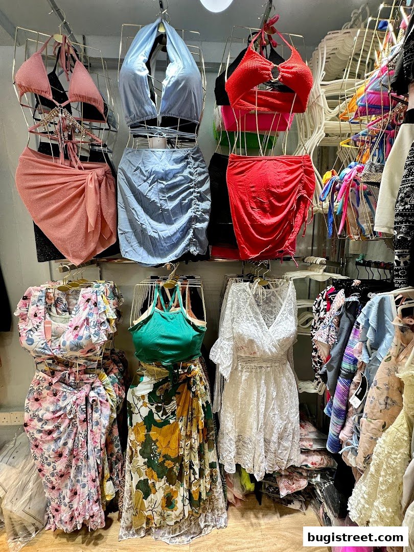 A display of women's clothing including bikinis, skirts, and dresses in various colors and styles.