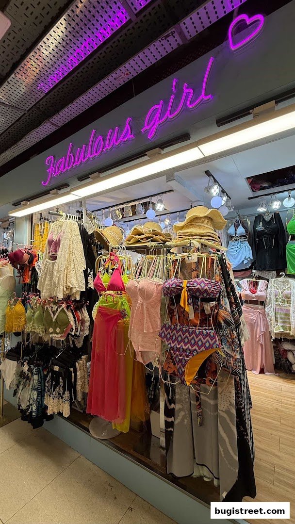 A vibrant shop display featuring colorful swimwear, hats, and stylish clothing.