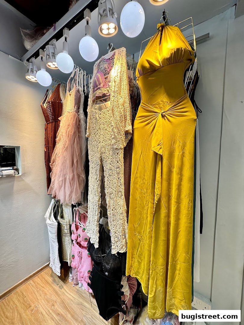 A collection of stylish women's clothing, including dresses and outfits, displayed on hangers.