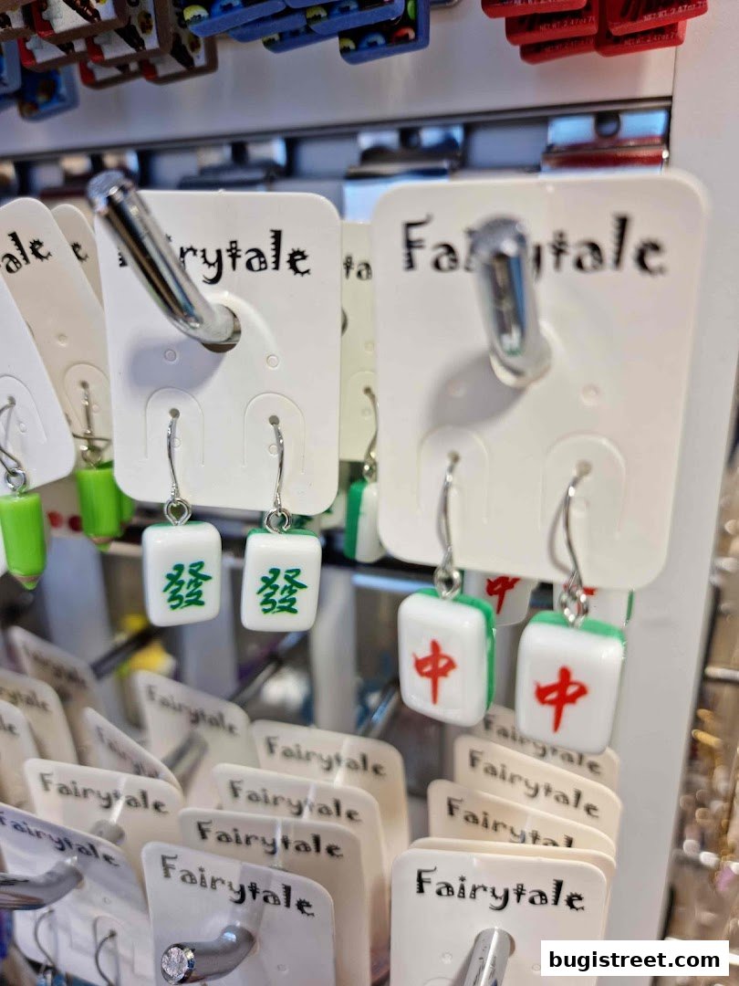 Close-up of unique Mahjong tile-themed earrings displayed on white cards.