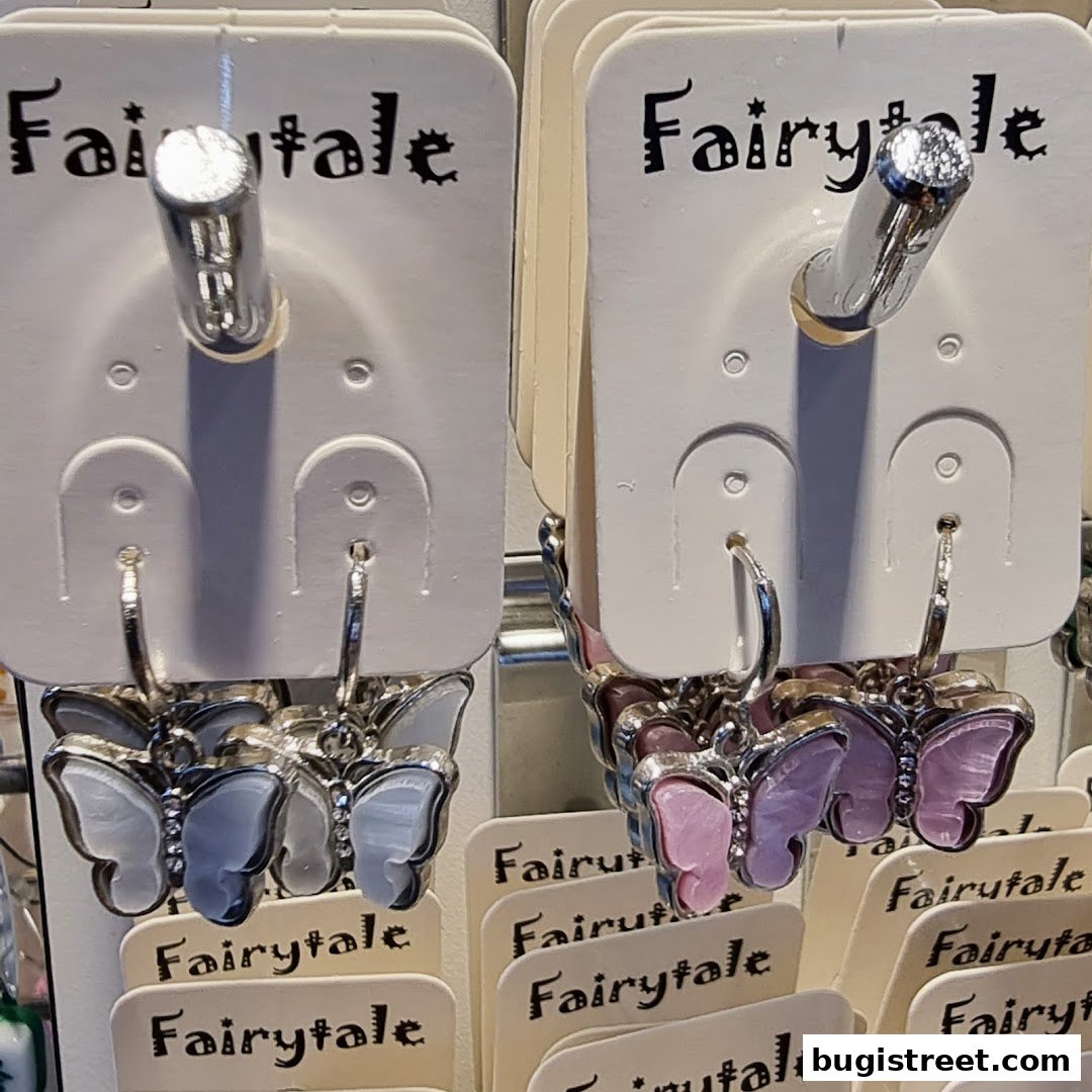 Close-up of butterfly-shaped earrings displayed on white cards with the 'Fairytale' logo.