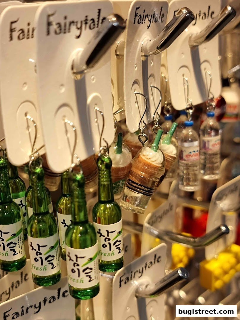 Close-up of novelty keychains shaped like miniature Korean soju bottles and coffee drinks.