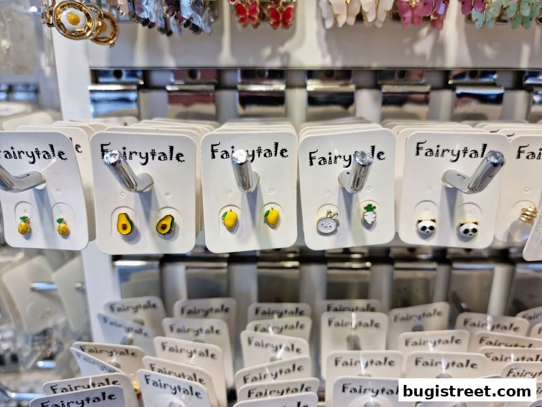 A display of cute, novelty earrings featuring fruits, animals, and food items.