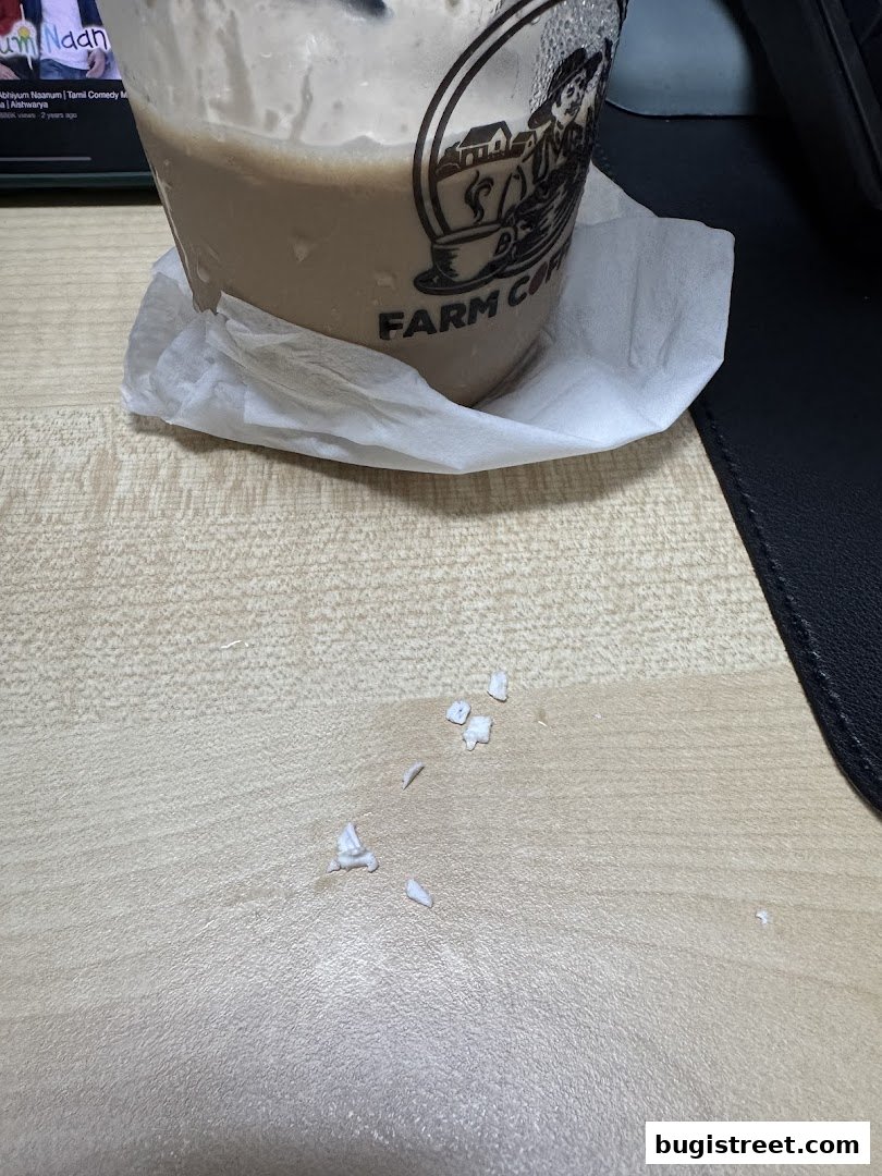 A close-up of a cold coffee drink with the Farm Coffee logo on the cup.