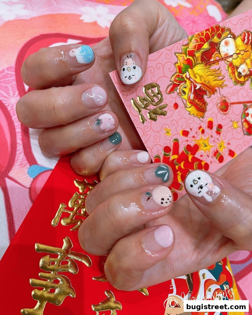 Close-up of hands with festive nail art featuring cute characters and floral designs.
