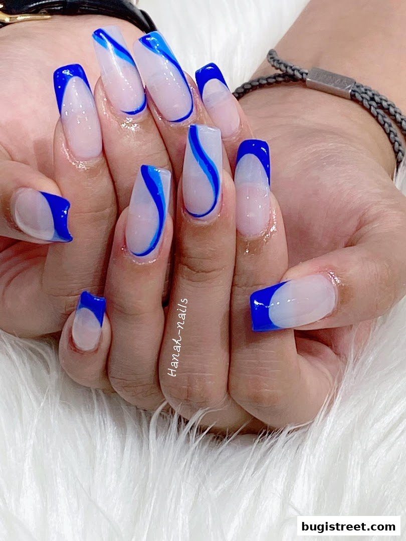 Close-up of hands with stylish blue and white French tip acrylic nails.