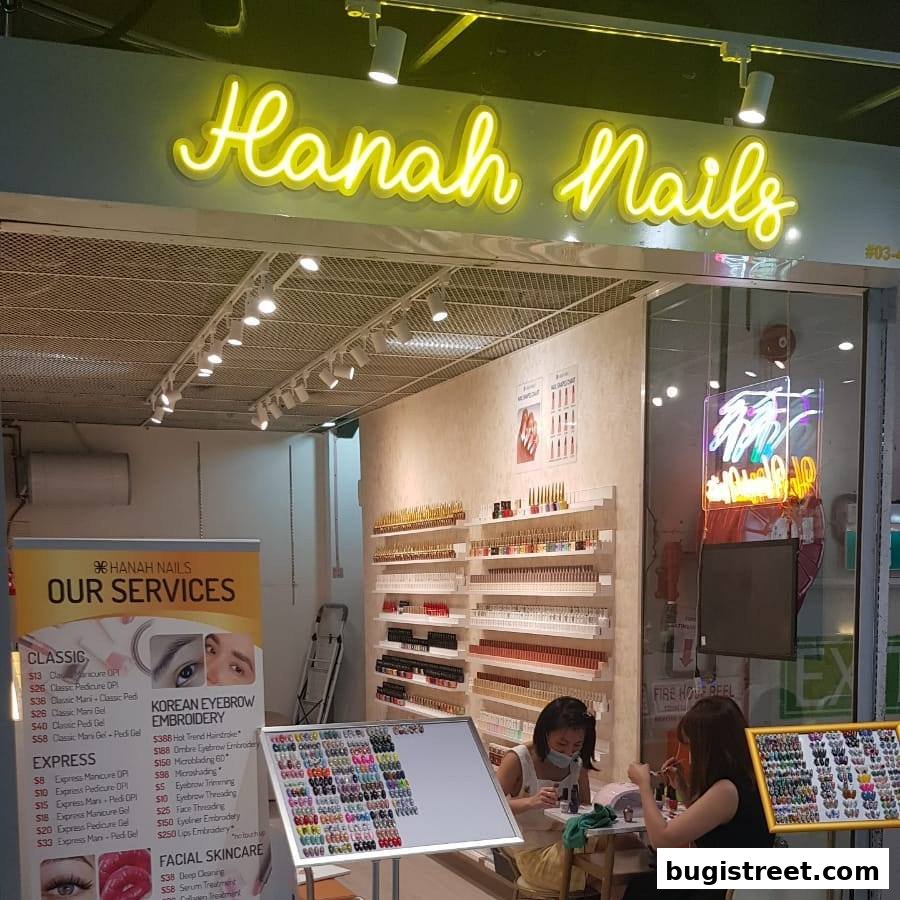 Nail salon interior with staff working and shelves stocked with nail polish.