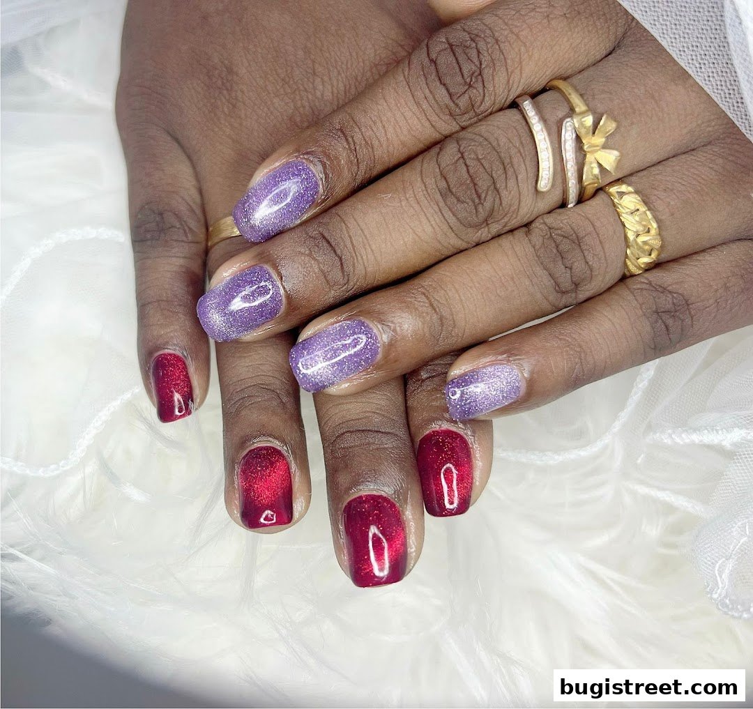 Close-up of hands with beautifully manicured nails in red and purple glitter.