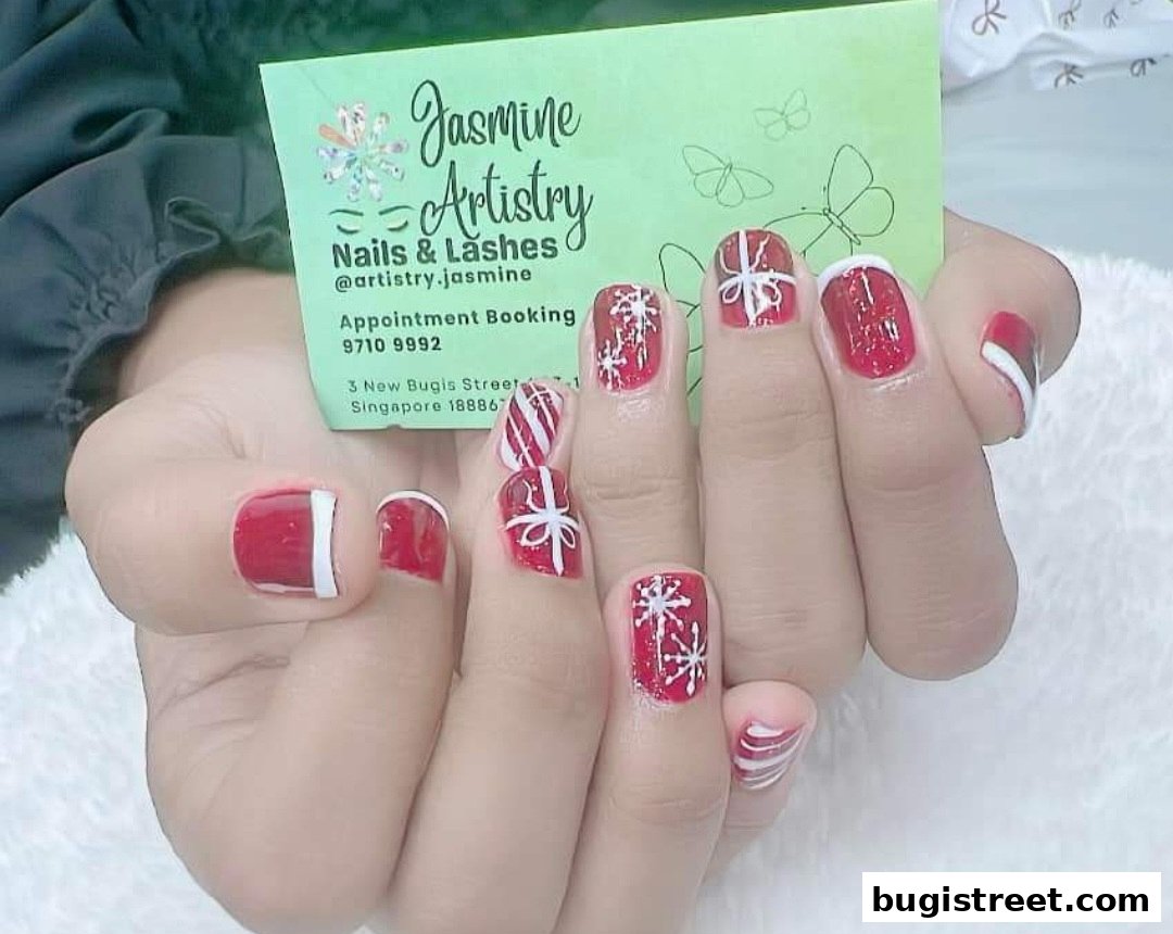 Close-up of hands with festive red and white Christmas-themed nail art.