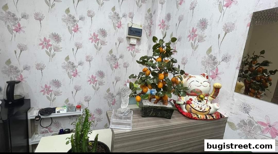 A decorative display featuring a lucky cat figurine, a jade orange tree, and a crystal sculpture.