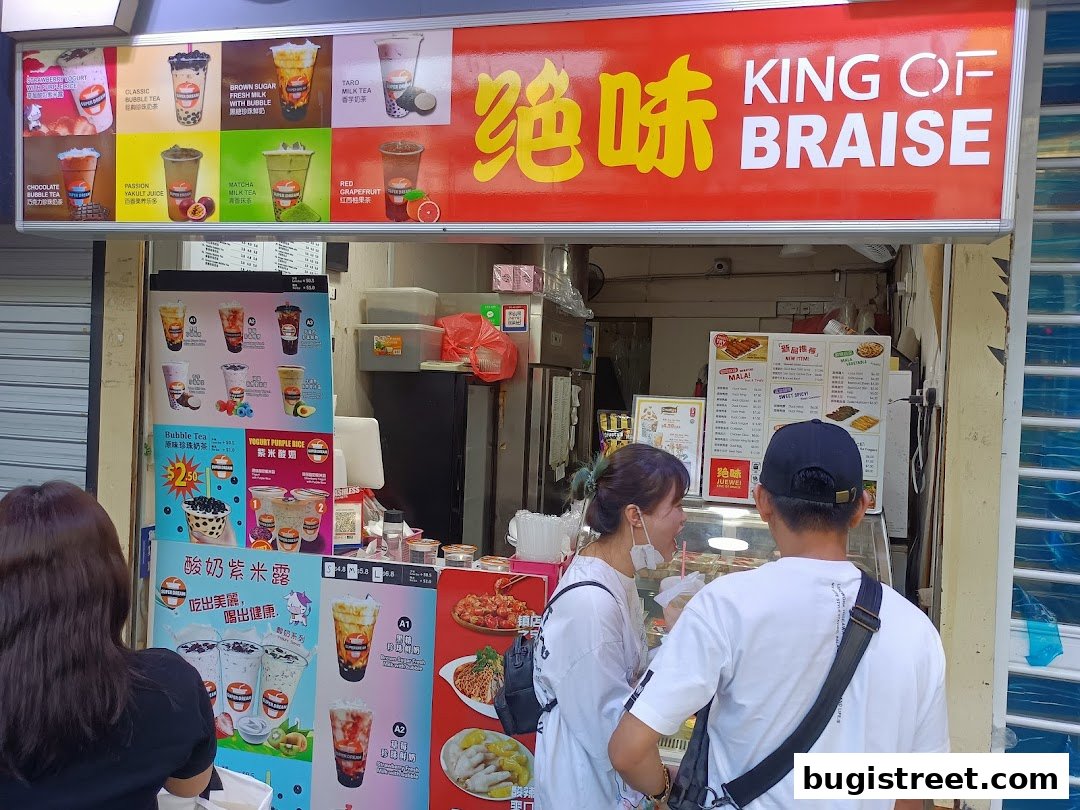 A JUEWEI shop front with a menu displaying various bubble tea and braised food items.