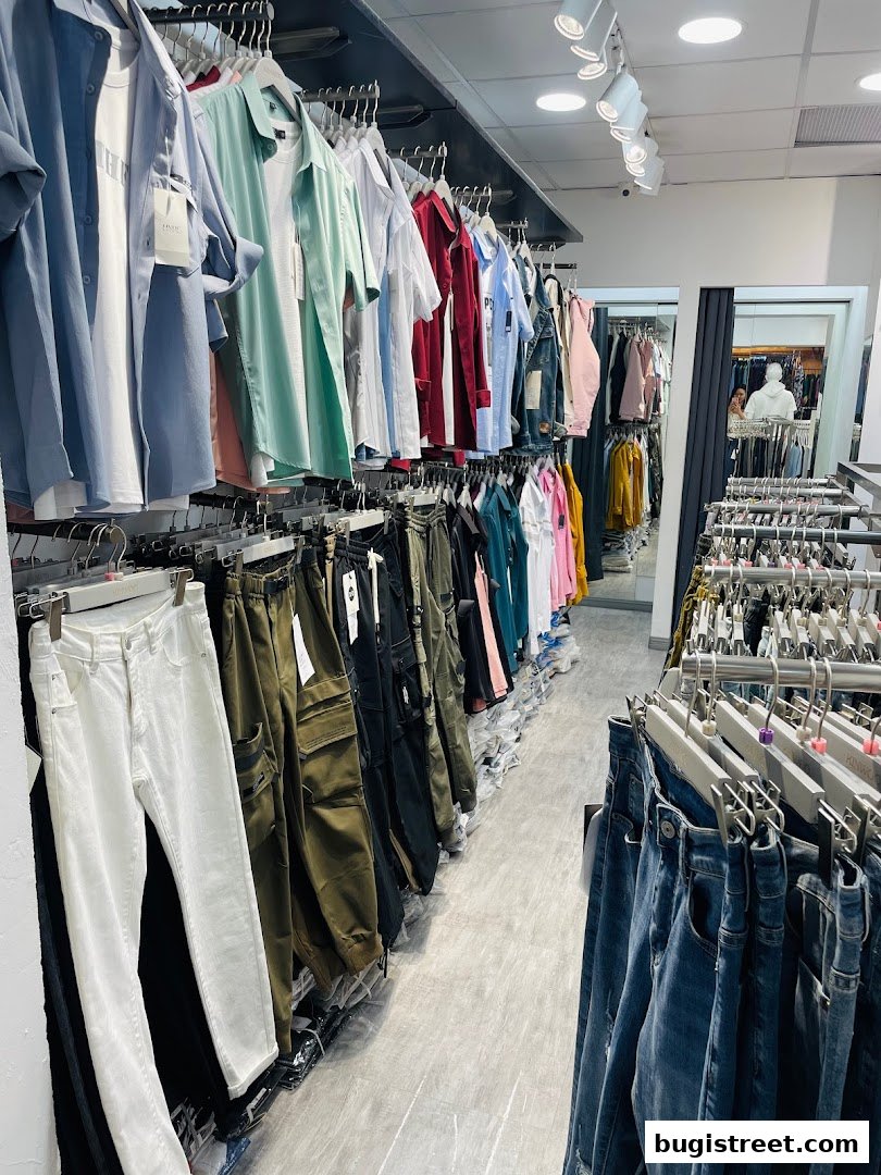 Interior view of a clothing store showcasing a wide selection of shirts and pants.