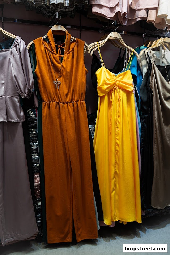 A selection of stylish women's clothing, including jumpsuits and dresses, displayed on hangers.
