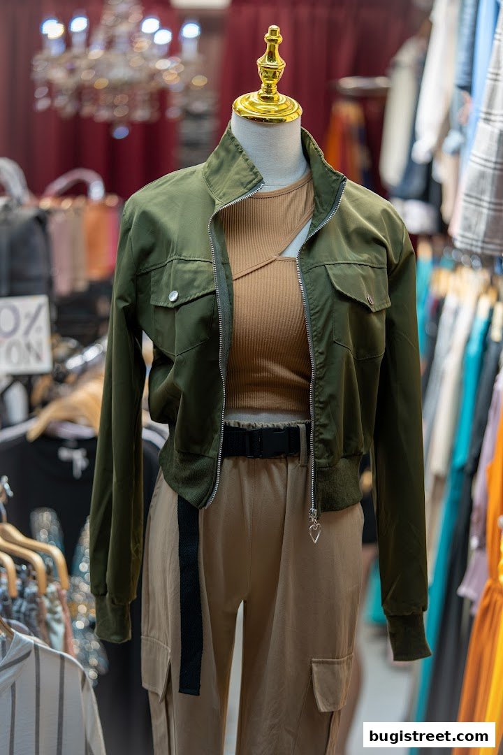 Mannequin wearing a green jacket, tan top, and cargo pants, displayed in a boutique.