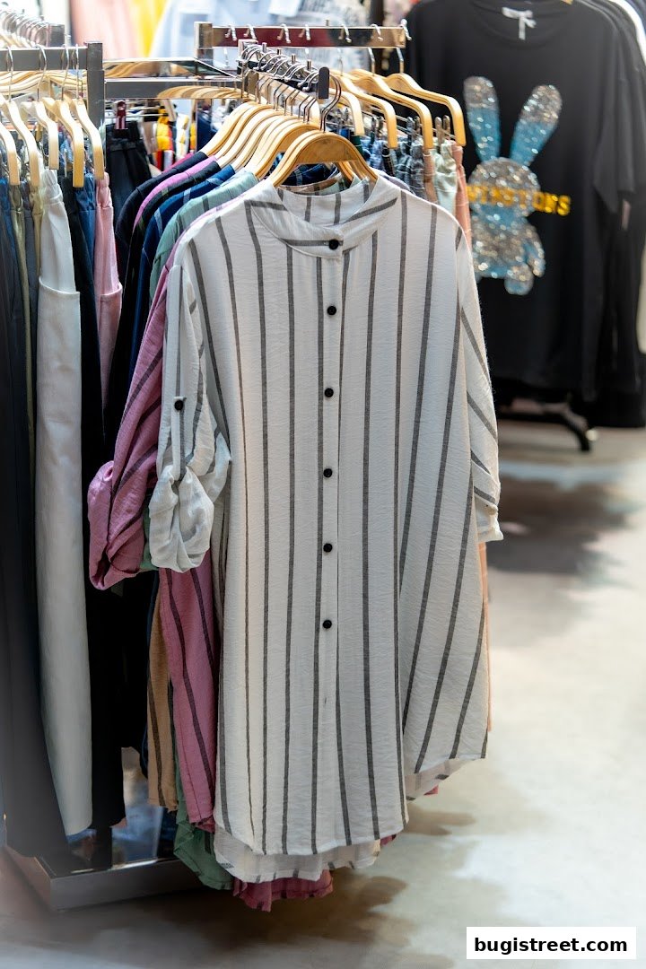 A rack of stylish women's clothing, featuring striped shirts and other apparel.