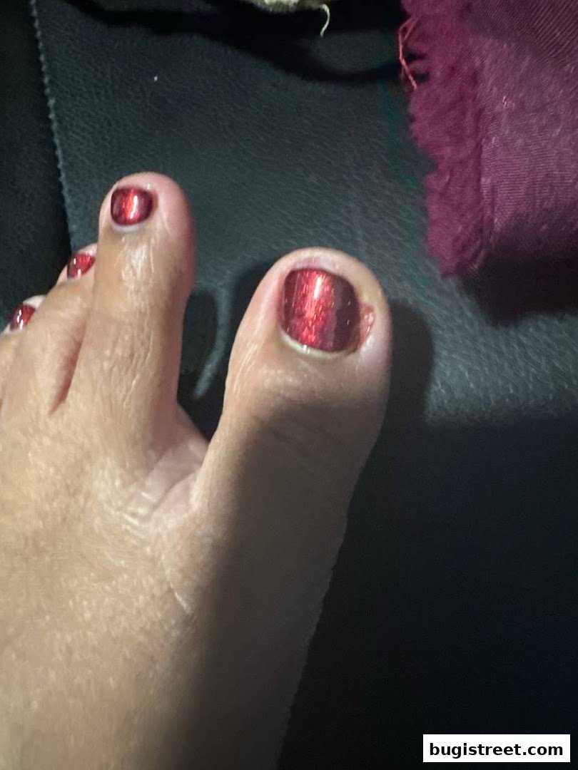 Close-up of a person's toes with shiny red nail polish.