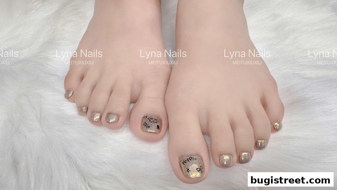 Close-up of feet with beautifully decorated toenails featuring metallic polish and cute designs.